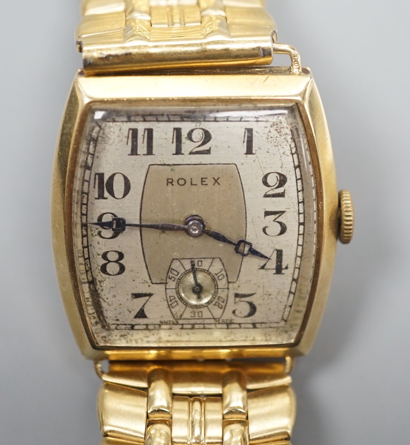 A gentleman's early 1930's 9ct gold Rolex manual wind wrist watch, with tonneau shaped case and Arabic dial with subsidiary seconds, on associated bracelet, case diameter 28mm.
